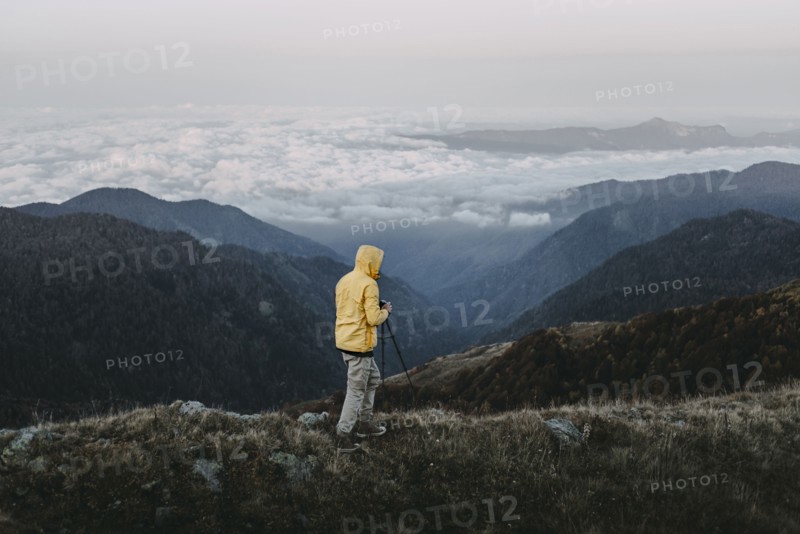 Caucasian man photographing in remote mountain landscape