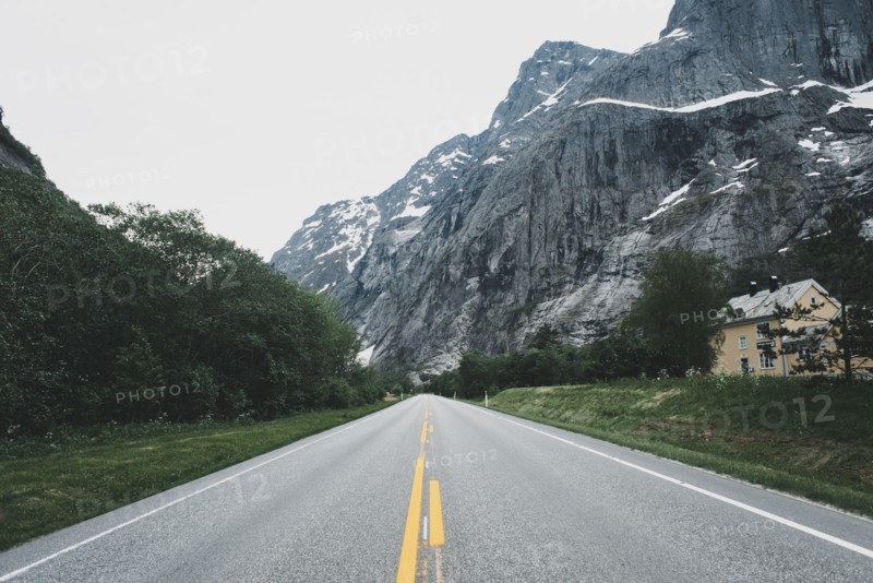 House near empty road in mountain landscape