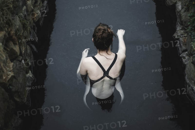 Caucasian woman swimming in pond