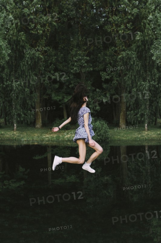 Caucasian woman floating over lake