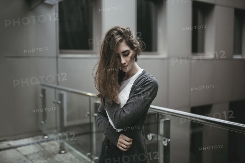 Pensive Caucasian woman standing near railing
