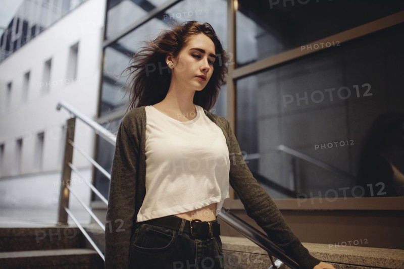 Wind blowing hair of pensive Caucasian woman on staircase