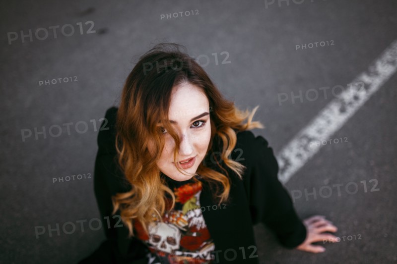 Caucasian woman sitting on street