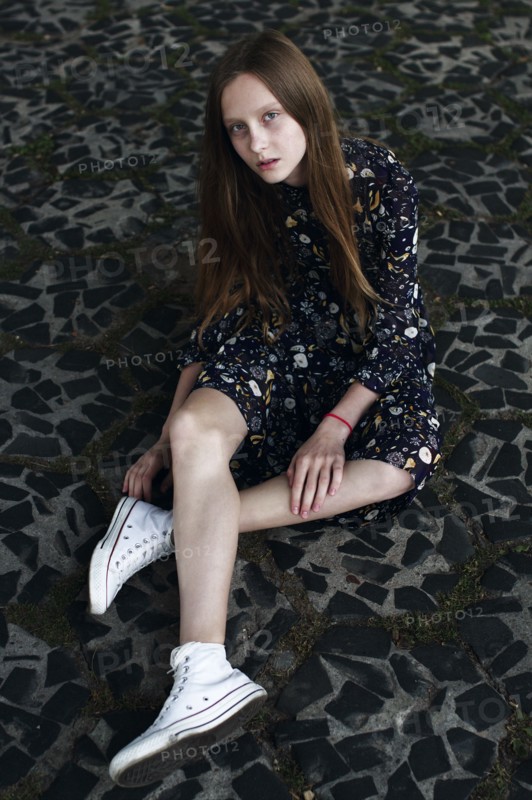 Caucasian woman sitting on stone floor
