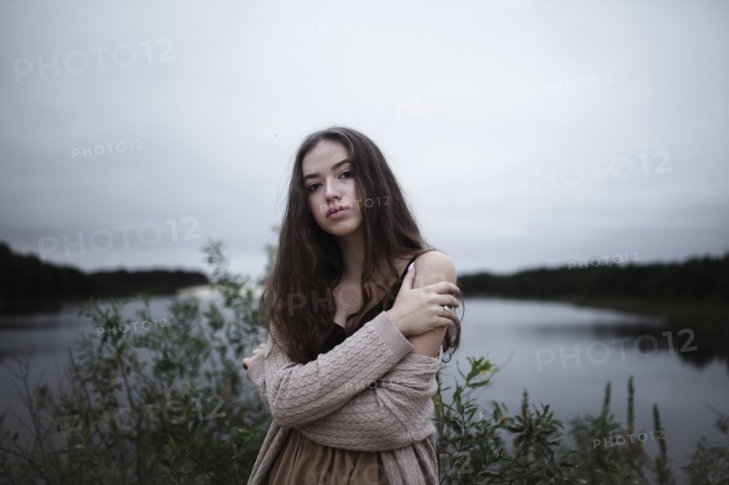 Portrait of serious Caucasian woman standing near a river