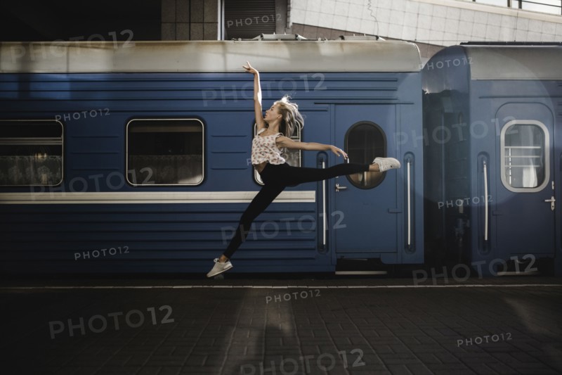Caucasian woman dancing near train