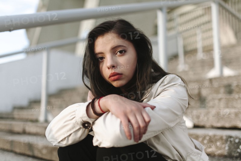 Serious Caucasian woman sitting on staircase