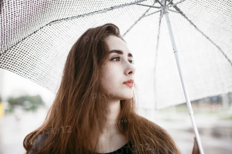Caucasian woman holding white umbrella
