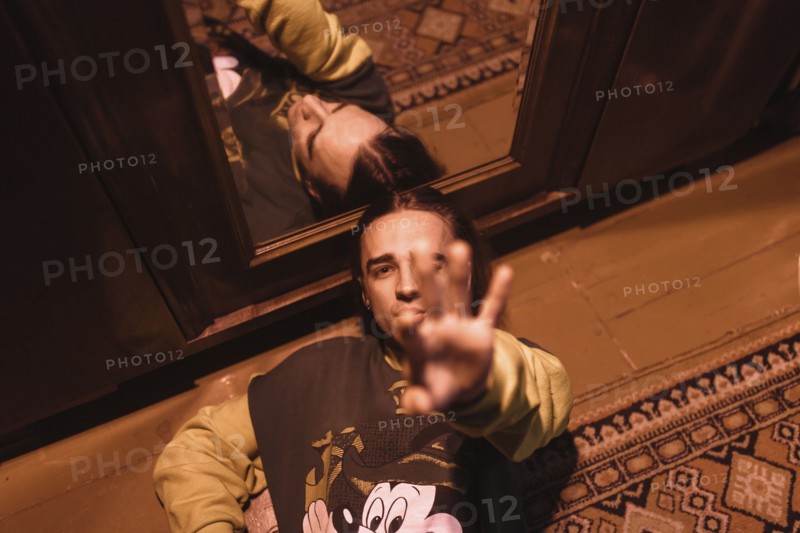 Caucasian man laying on floor near mirror