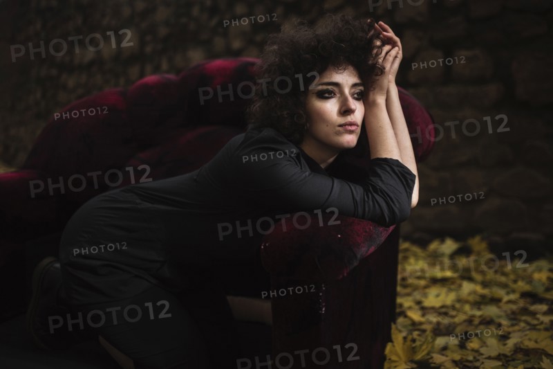 Pensive Caucasian woman laying on sofa outdoors
