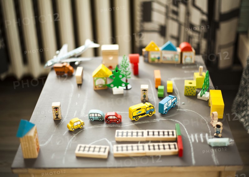 Wooden buildings and car toys on table