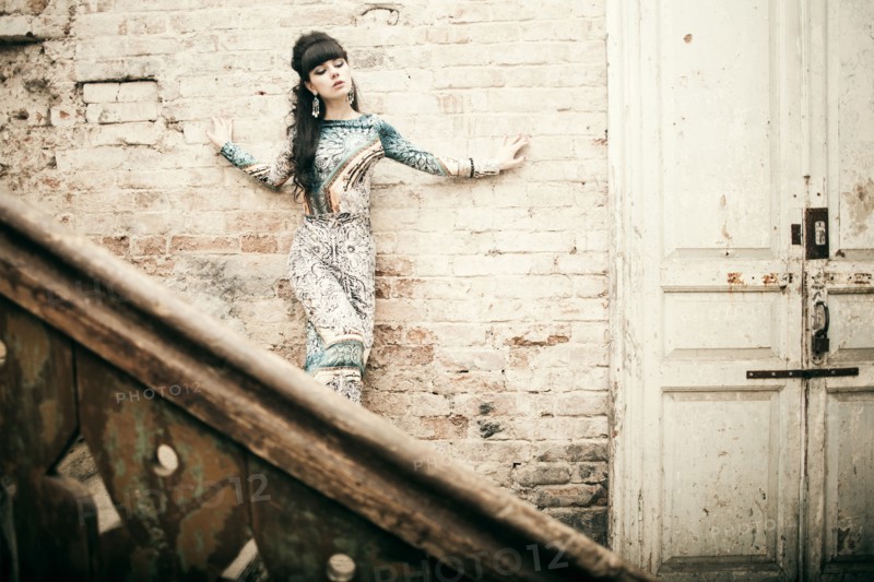 Caucasian woman standing on staircase in dilapidated house