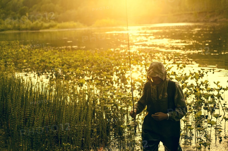 Mari fisherman carrying fishing rod at lake