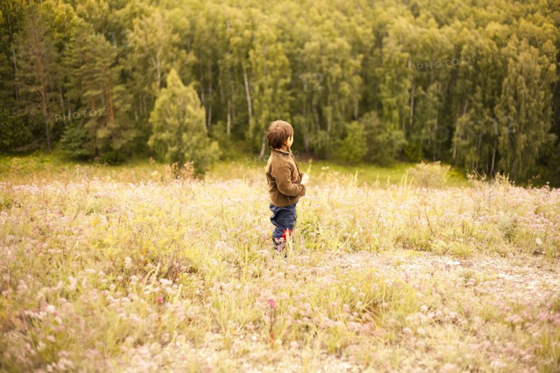 Mixed race boy standing in rural field
