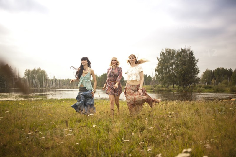 Caucasian women walking in field near lake