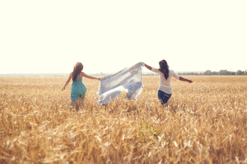 Caucasian women carrying blanket in rural field
