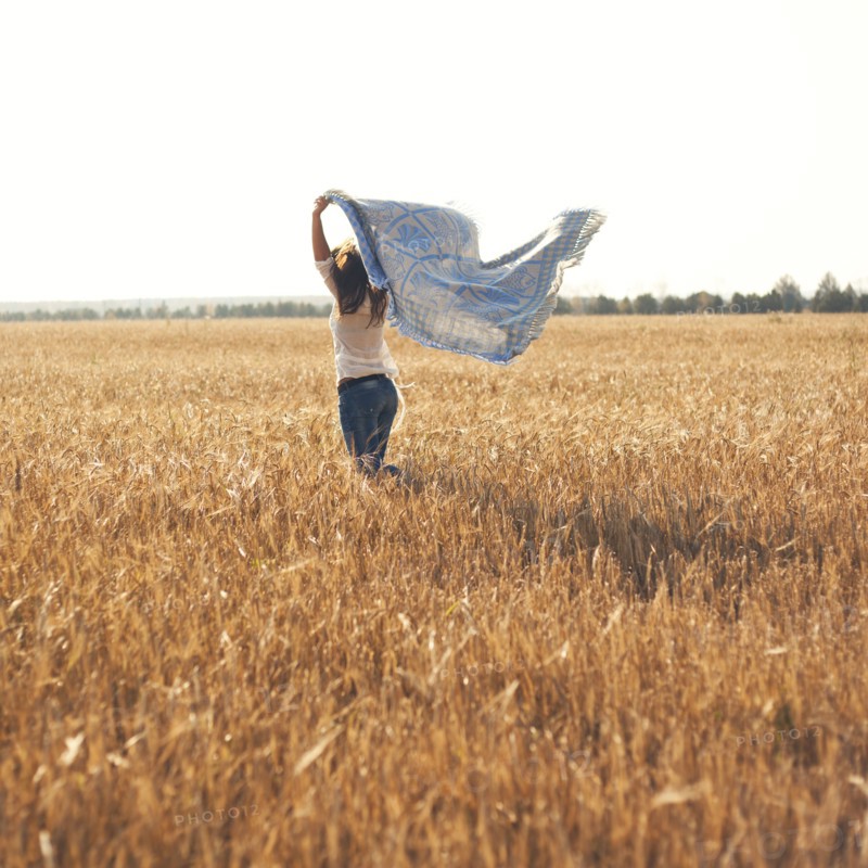 Caucasian woman carrying blanket in rural field