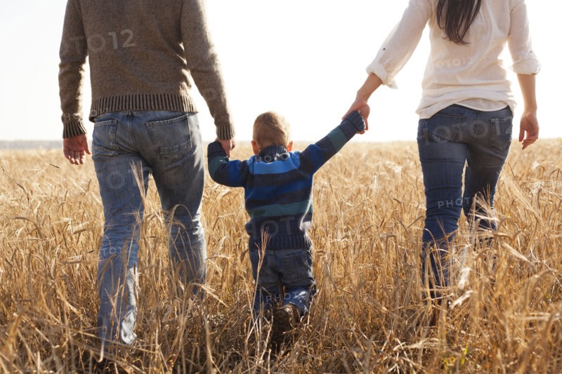 Caucasian family walking in rural field