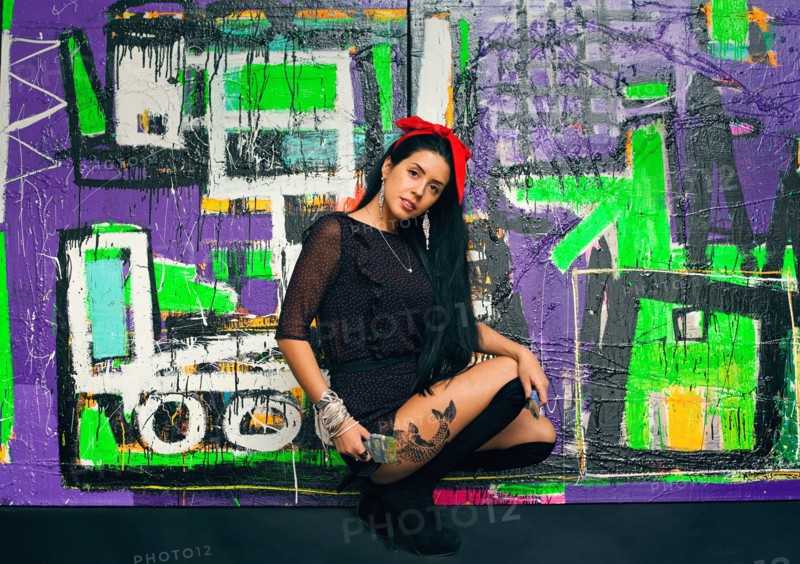 Woman posing in front of colorful graffiti wall