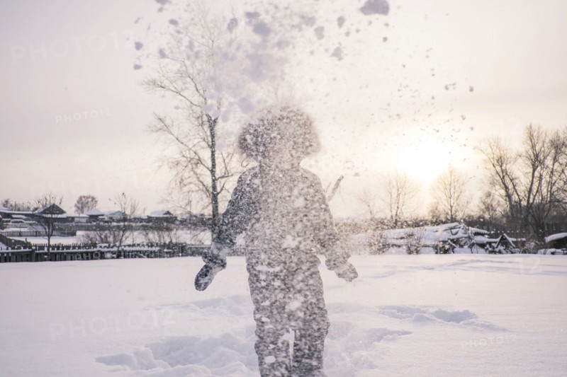 Mari boy in parka playing in snowy field