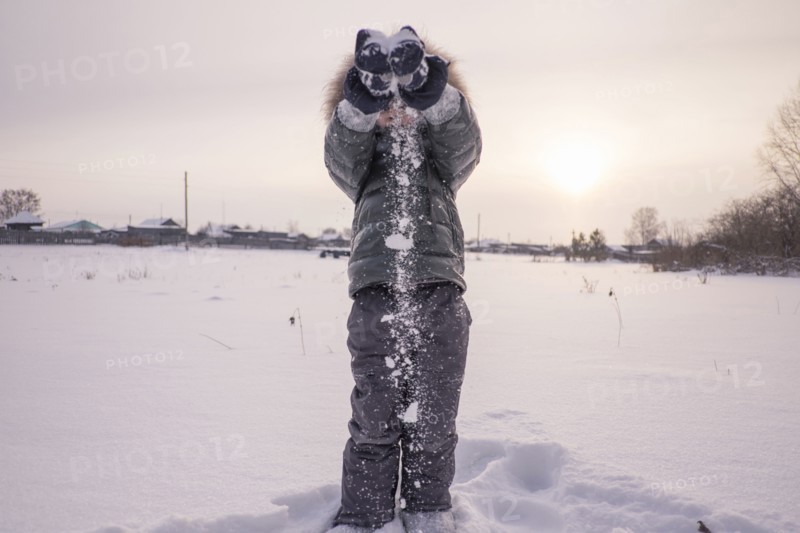 Mari boy in parka playing in snowy field