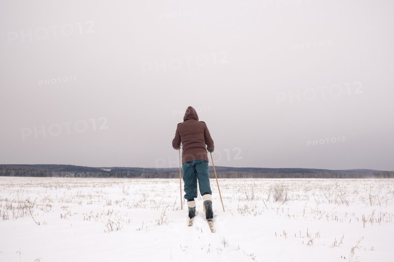 Woman cross-country skiing in snowy field