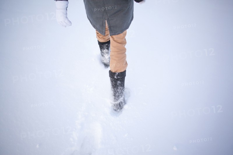 High angle view of Caucasian woman walking in snowy field