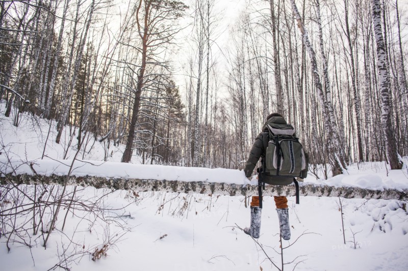 Mixed race man walking in snowy forest