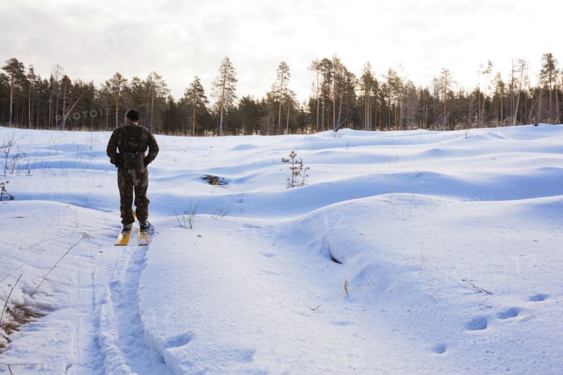 Caucasian man cross country skiing in snowy field