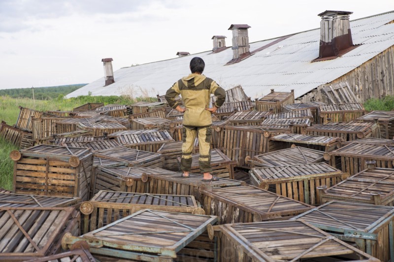 Mari man standing on wooden crates near roof