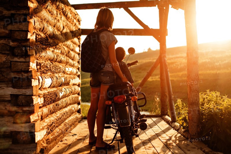 Mother holding son on motorcycle on patio