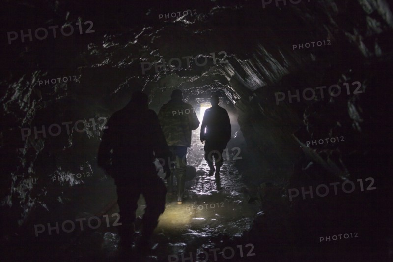 Men walking in dark cave