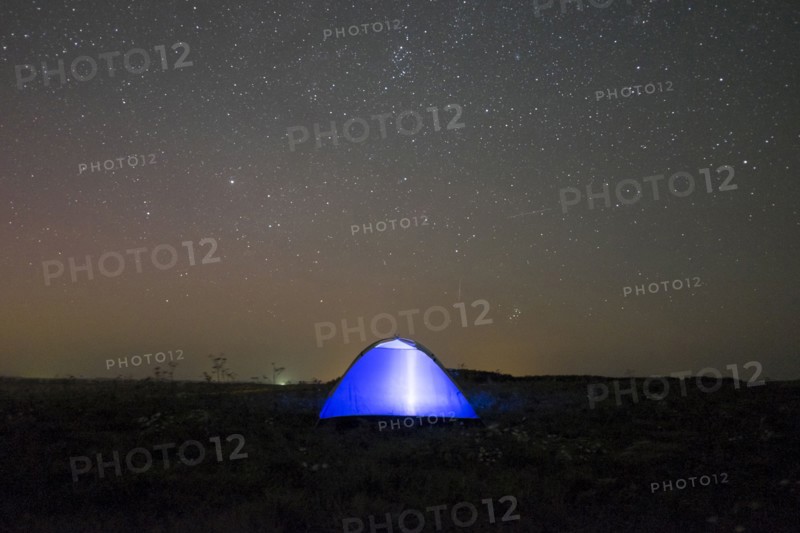 Glowing tent under starry night sky