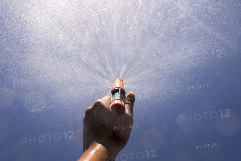 Mari boy spraying nozzle to blue sky