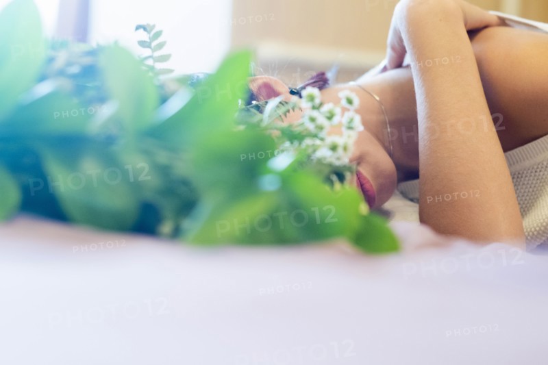 Face of Caucasian woman obscured by roses