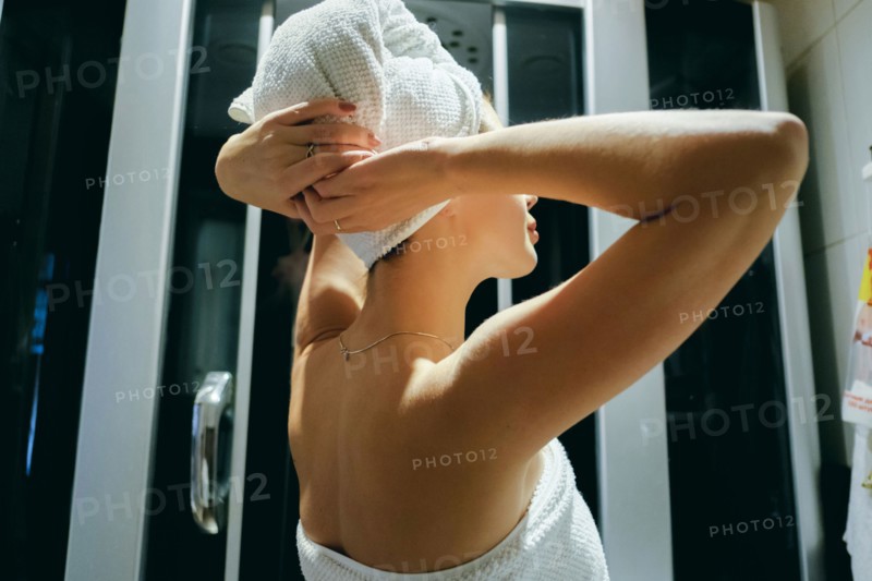 Caucasian woman drying hair with towel