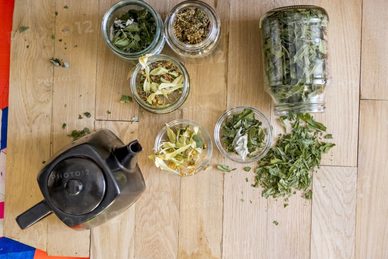 Teapot and tea leaves on table