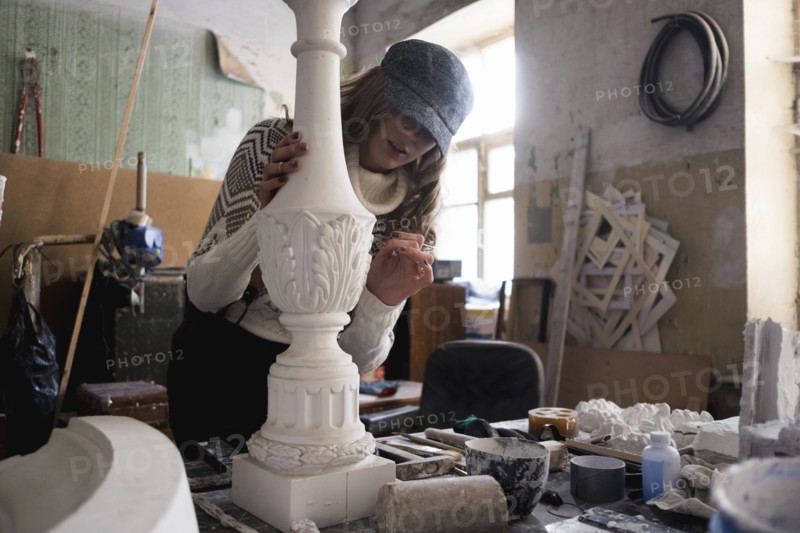 Caucasian sculptor carving plaster piece