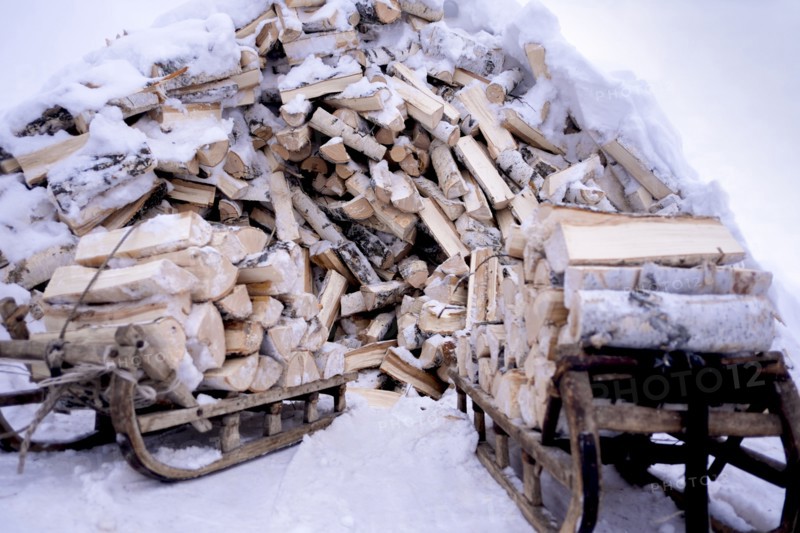 Snow covered firewood on wooden sleds