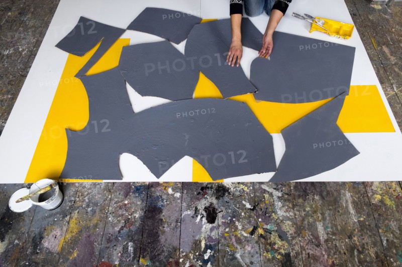 Caucasian artist arranging pieces of painting