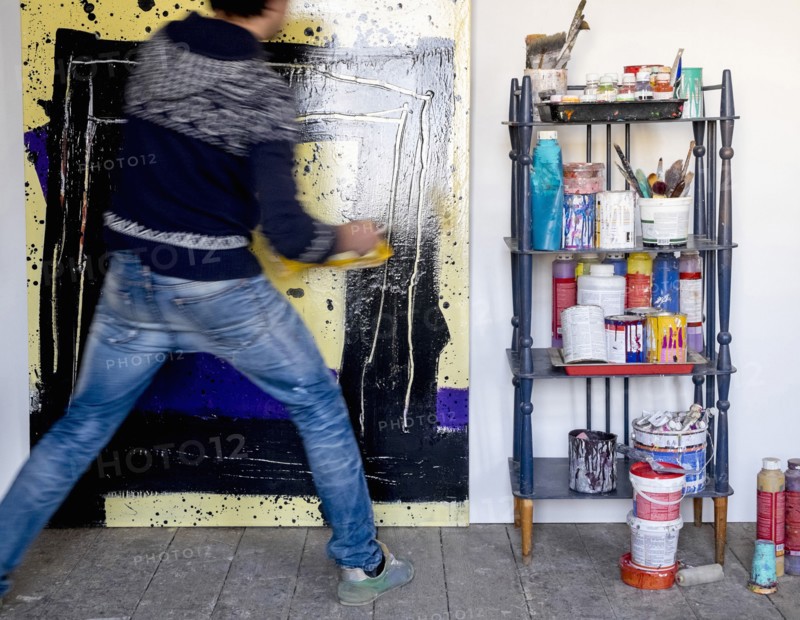 Caucasian artist holding painting with pain roller