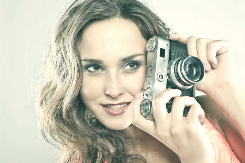 Smiling Caucasian woman holding camera