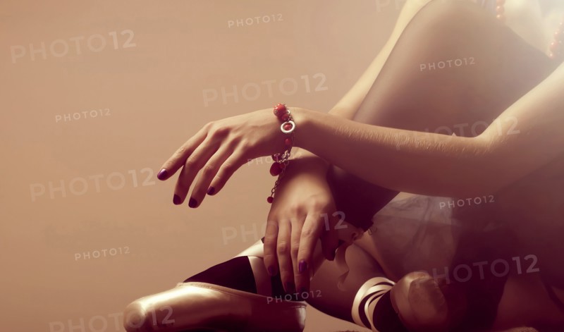 Arms and legs of Caucasian ballerina sitting on floor