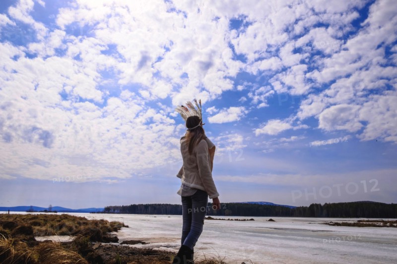 Caucasian woman wearing headdress near river