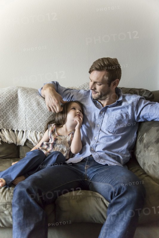 Father and daughter sitting on sofa