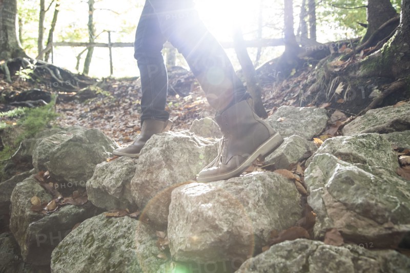 Legs of Caucasian man walking on rocks
