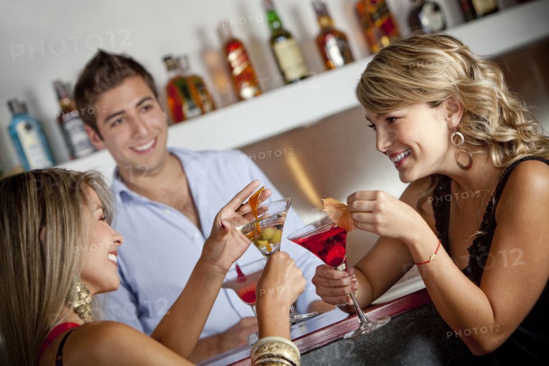 Hispanic friends drinking cocktails in bar