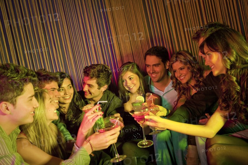 Hispanic friends drinking cocktails in bar