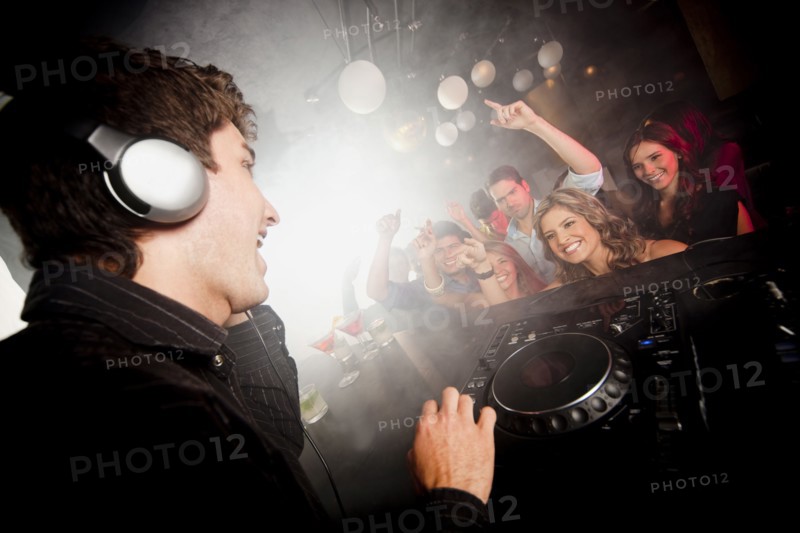 DJ playing music for crowd in nightclub