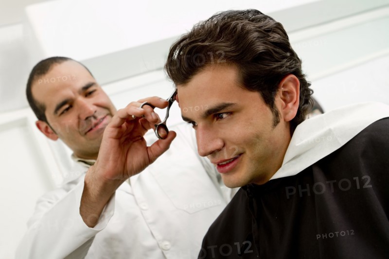 Hispanic man having hair cut in barber shop
